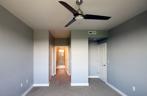Reno Apartments for Rent - Bedroom with Carpet, Natural Light, Access to Bathroom, and a Ceiling Fan